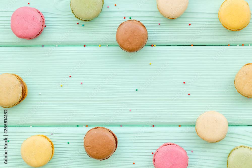 Macarons design on mint green wooden background top view space for text