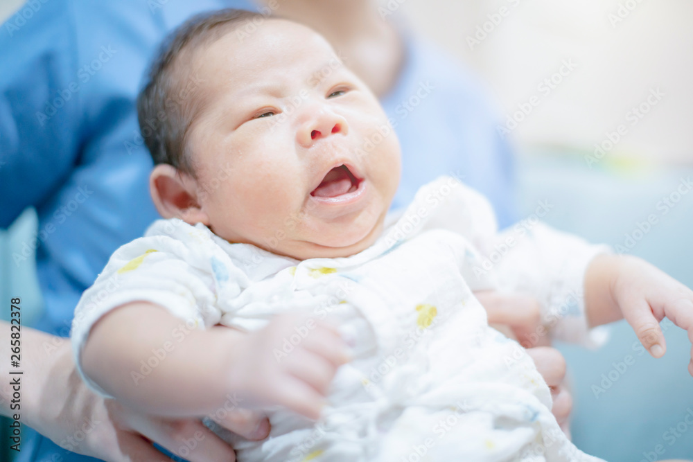 cute asian infant baby boy hungry cry  in mom arm with love and careful