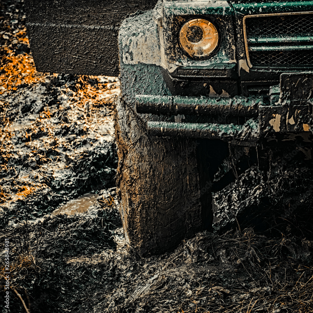 4x4 travel trekking. Offroad vehicle coming out of a mud hole hazard. Off-road travel on mountain ro