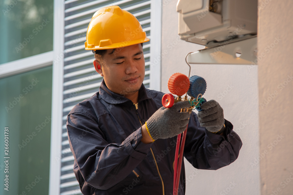 Technician are checking outdoor air conditioner unit,Measuring equipment for filling air conditioner