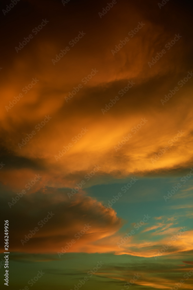 Beautiful vibrant orange cloud and blue sunset sky . Vertical format