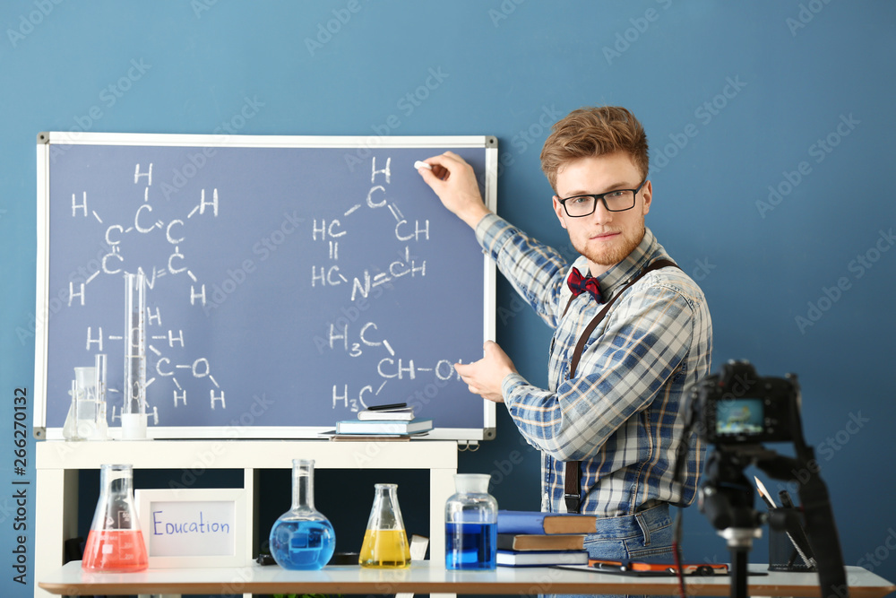 Young male blogger recording video in laboratory