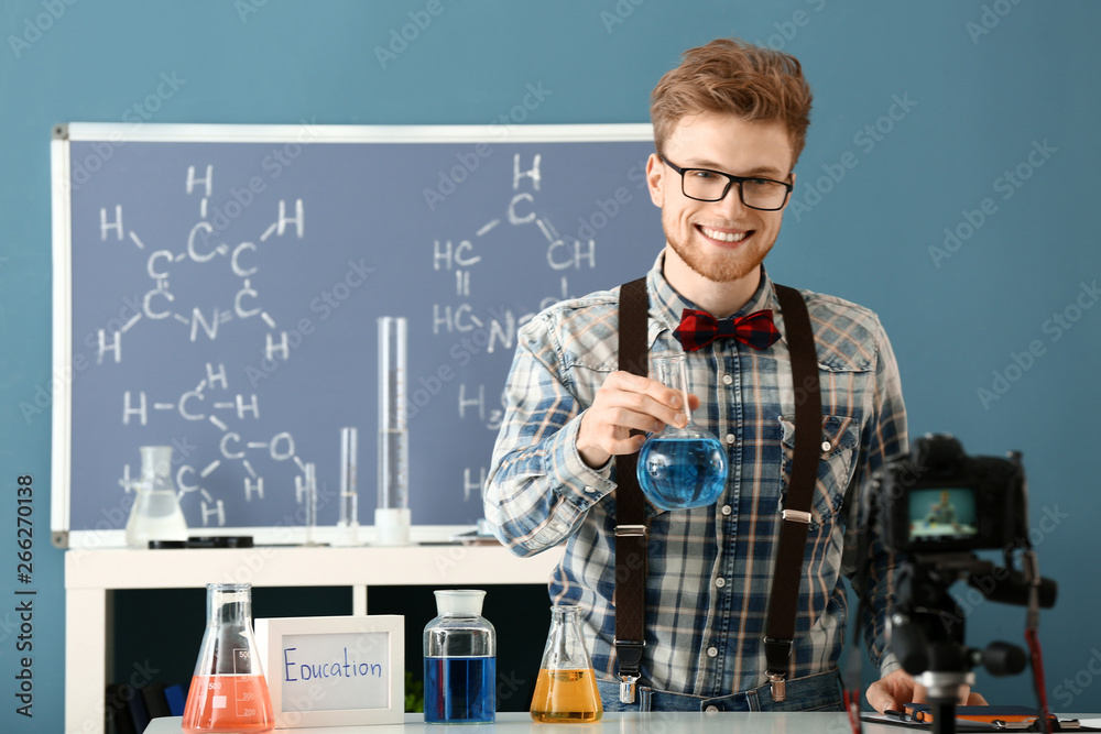 Young male blogger recording video in laboratory