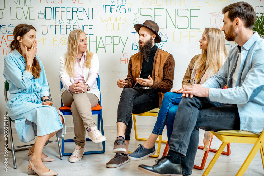 Young people sitting together during the psychological therapy, solving together some mental problem