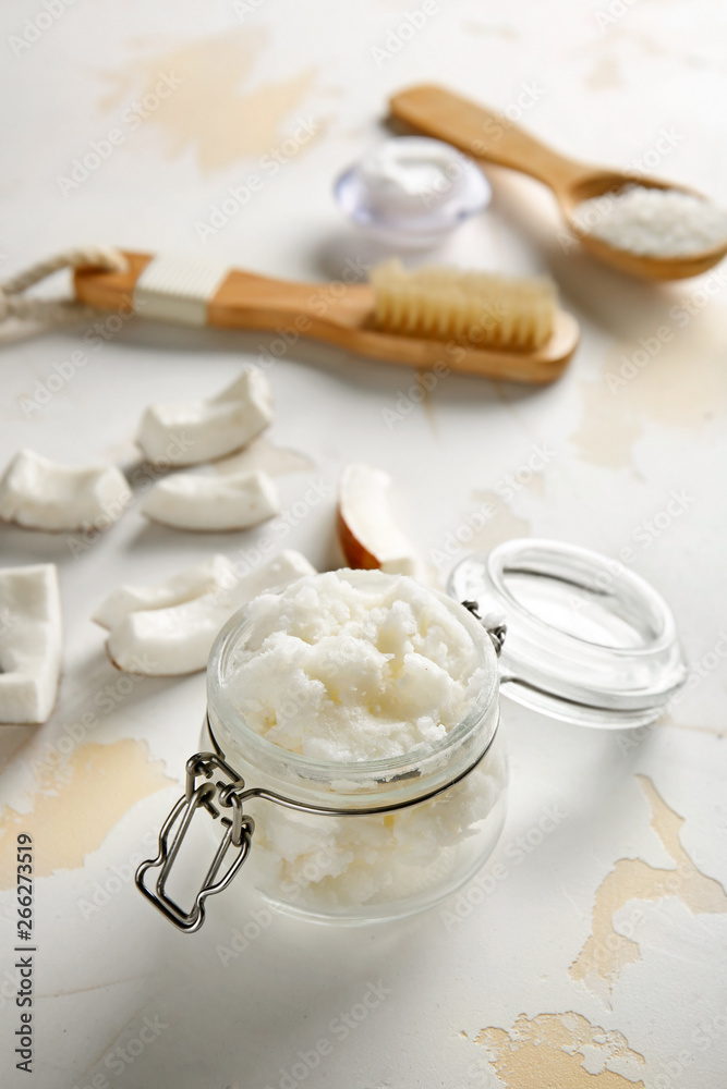 Jar with coconut body scrub on white background