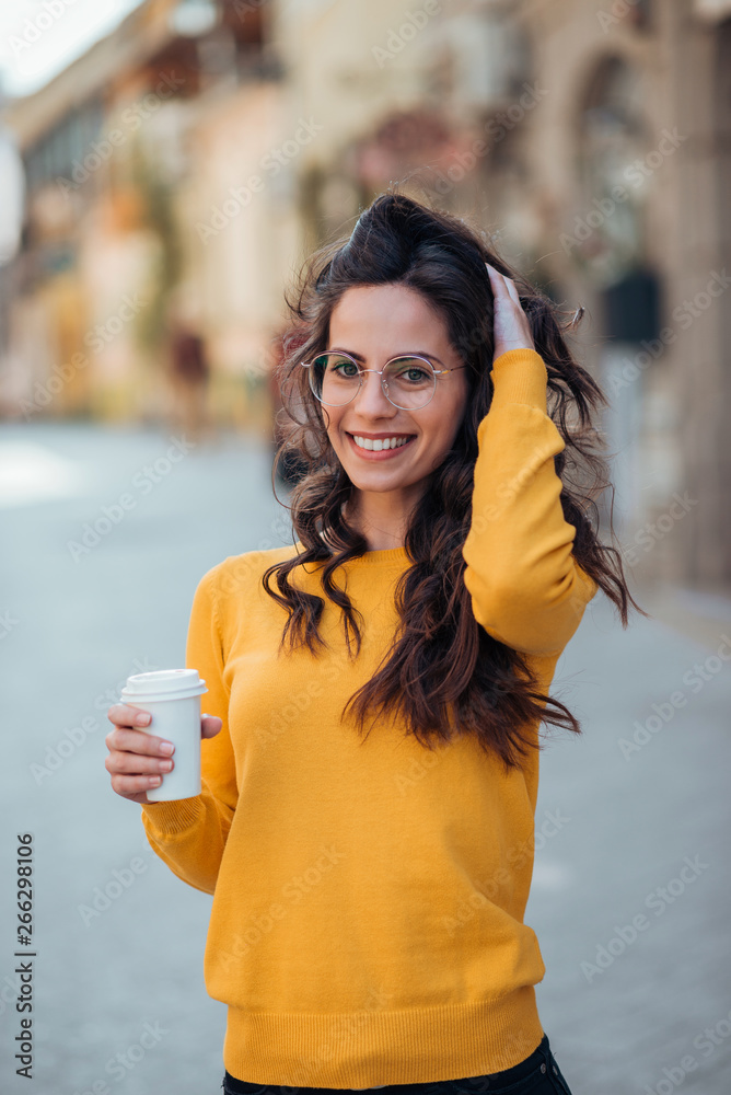 一个拿着外卖饮料的休闲女人的画像。