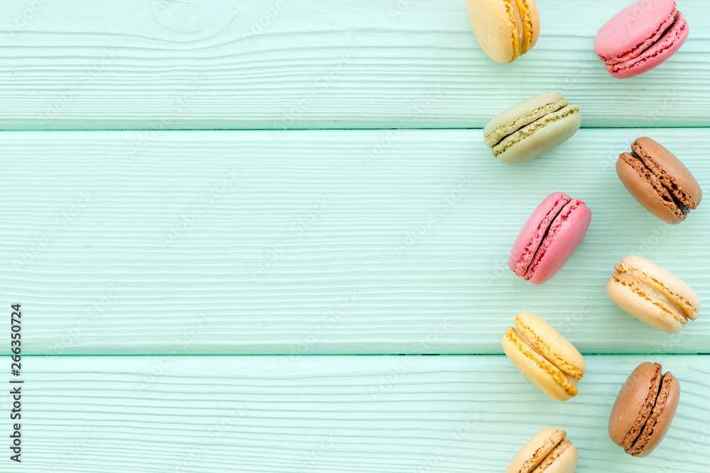 Brignt macarons for sweet break on mint green background top view mock up