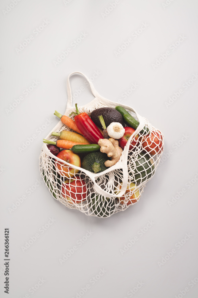 Fresh organic fruits and vegetables in mesh textile bag