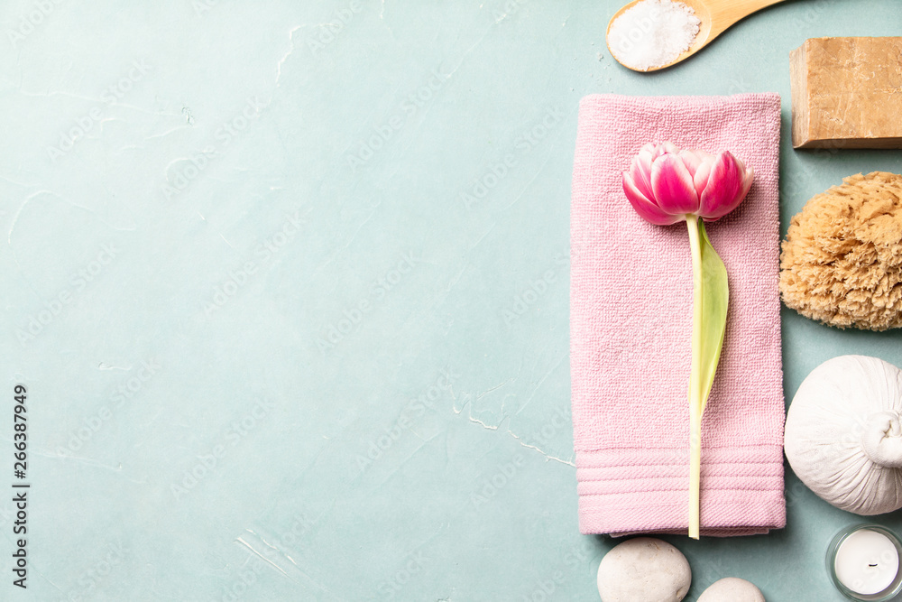 Flat lay of spa treatment set with pink flowers