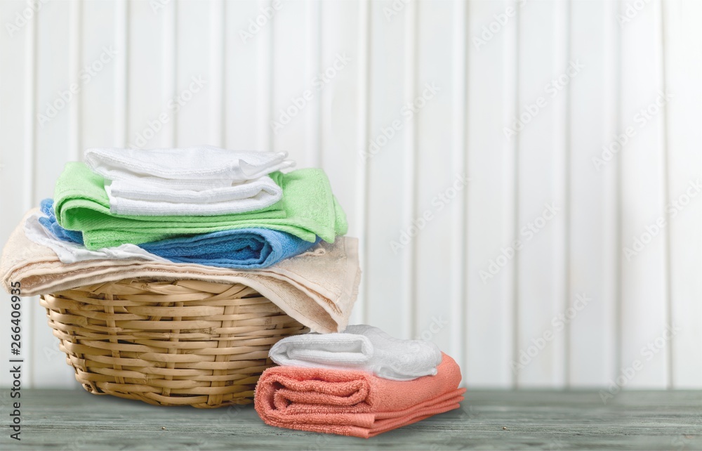 Laundry Basket with colorful towels on background