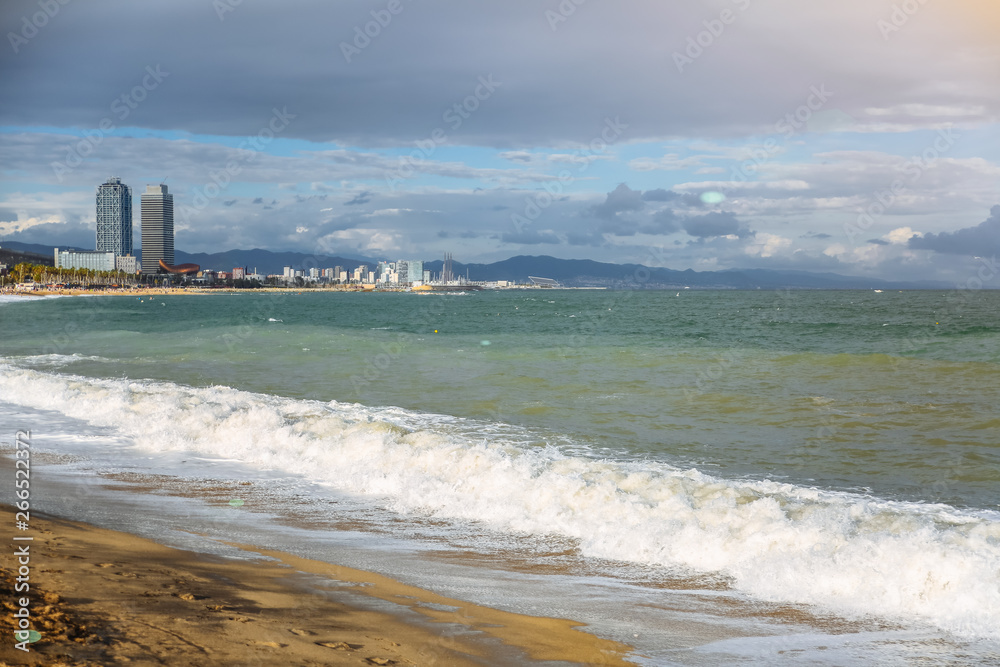 阳光明媚的日子里，美丽的海滩。海上的海浪。假日旅行的概念。巴塞罗那的西班牙景色。