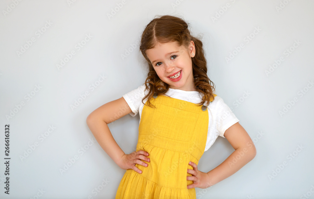  happy cheerful child girl in yellow dress.