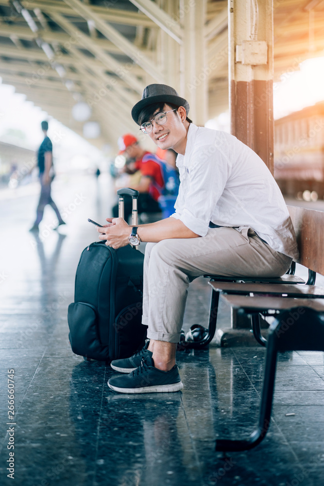 亚洲人是旅行者，他在等他们的火车。户外冒险旅行的火车概念。禁止