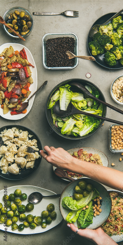 Vegan dinner table setting. Healthy dishes in plates on table. Flat-lay of vegetable salads, legumes