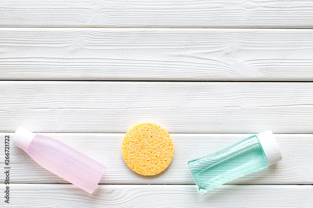 skin care cosmetics with facial tonic, mycelial water and sponge on white wooden background top view