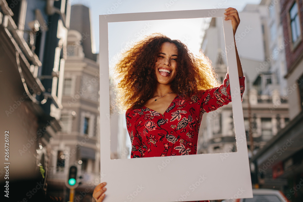 Funny young woman with a blank photo frame