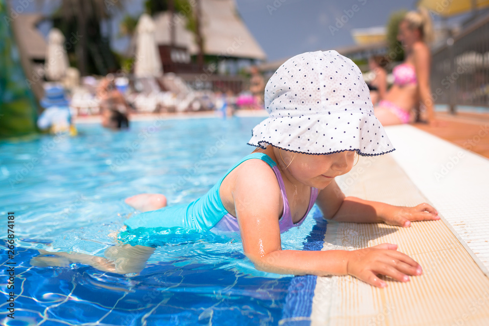 Happy little girl play at the pool on summer holidays