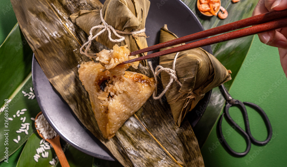 粽子，绿色餐桌背景下吃蒸饺的女人，端午节的食物