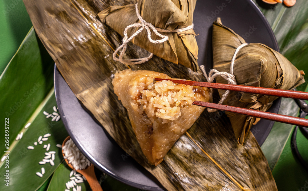 粽子，绿色餐桌背景下吃蒸饺的女人，端午节的食物