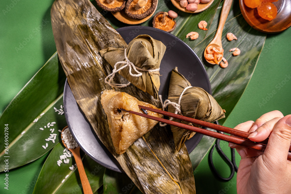 粽子，绿色餐桌背景下吃蒸饺的女人，端午节的食物