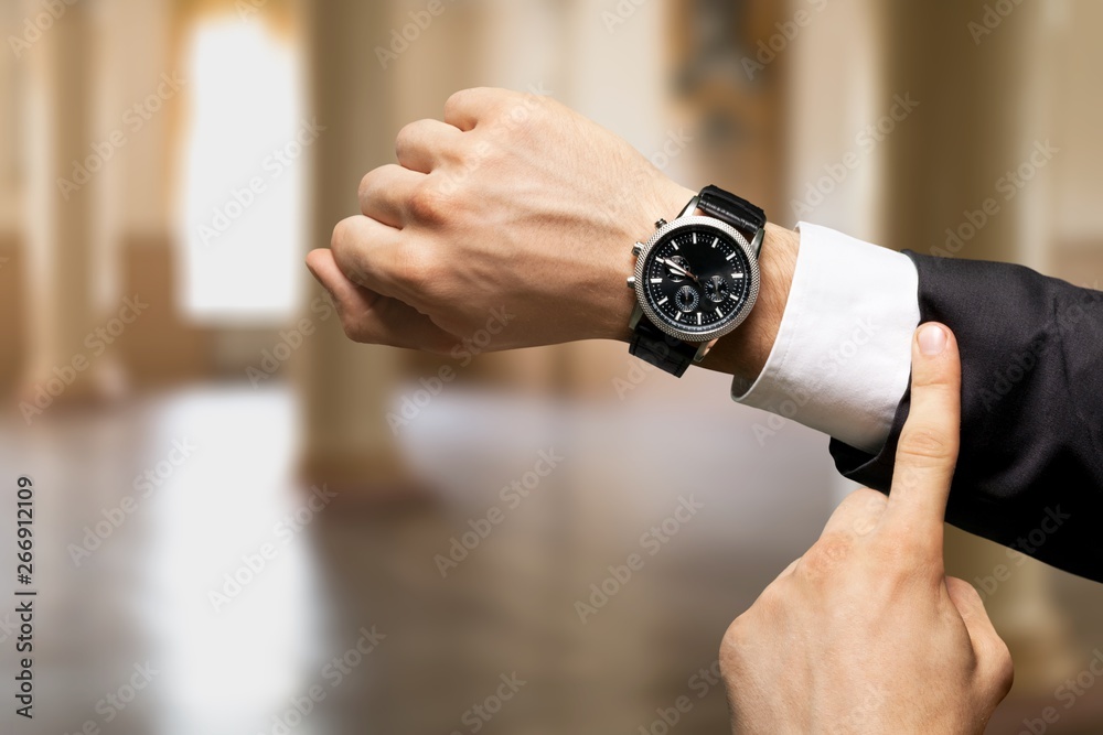 Businessman with hand watch on background, close-up