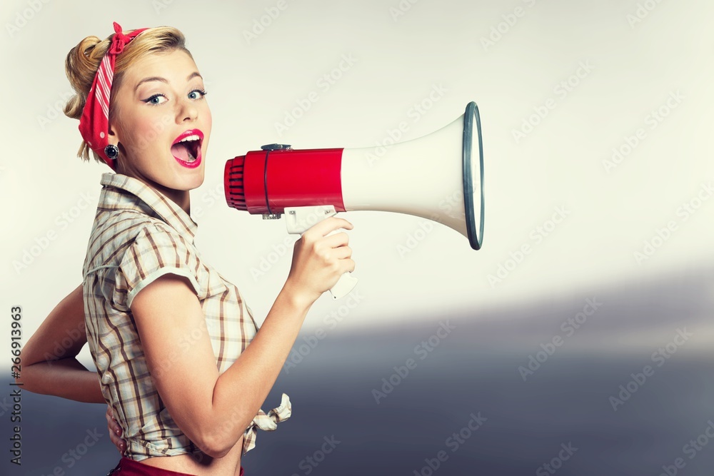 Portrait of woman holding megaphone, dressed in pin-up style