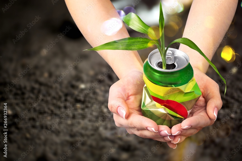 Hands holding metal can on background