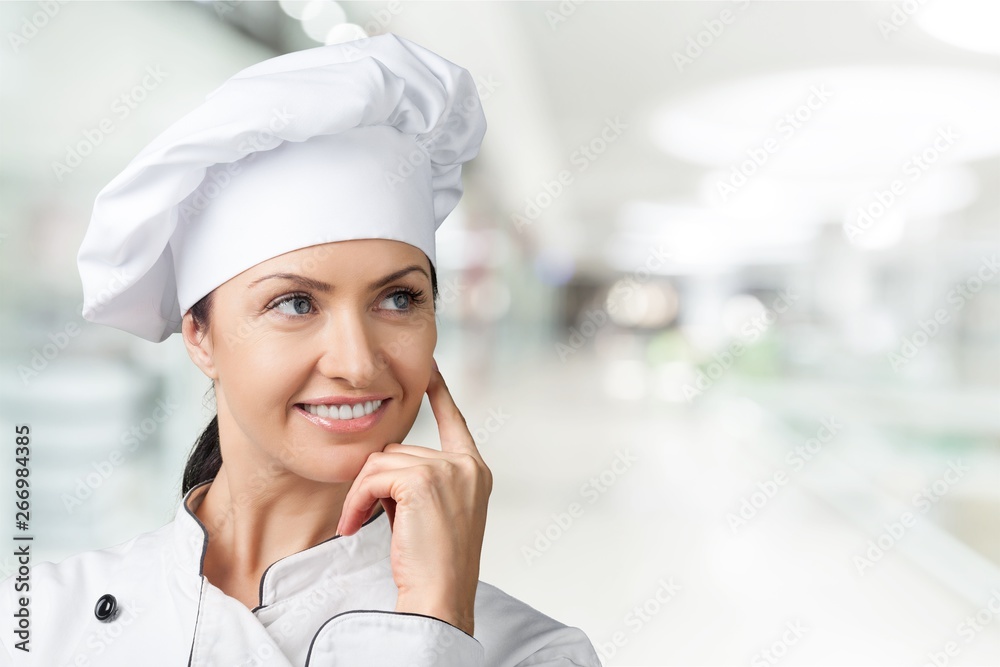 Portrait of young woman chef on background