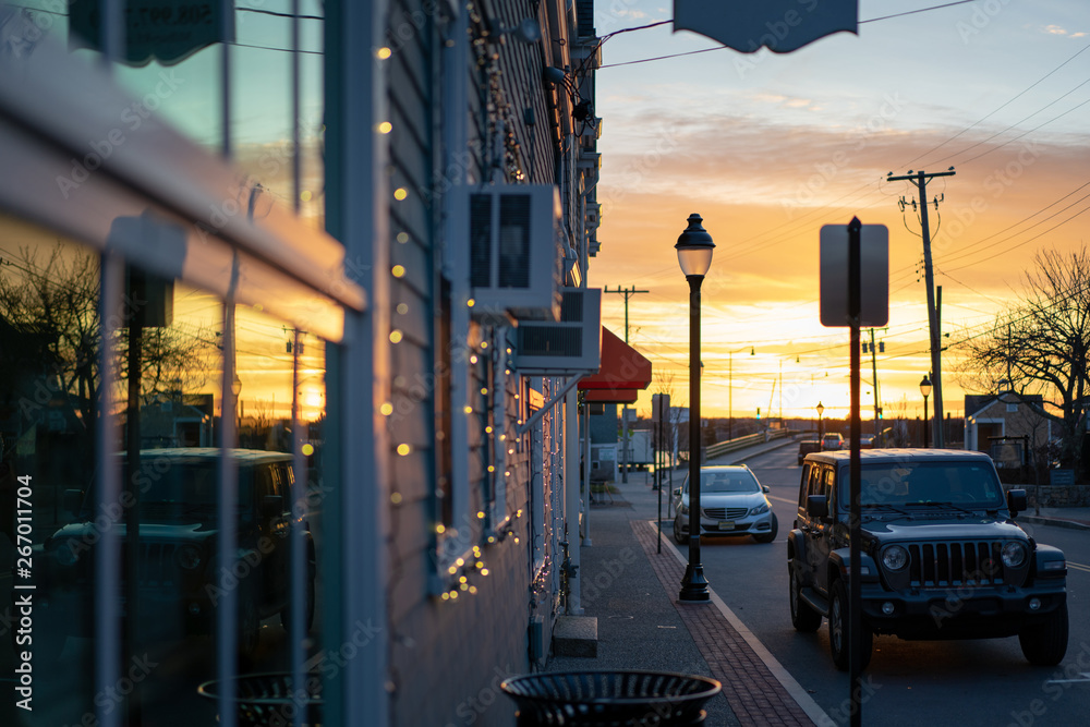 Storefront windows reflecting sunset, small town street, near harbor ocean