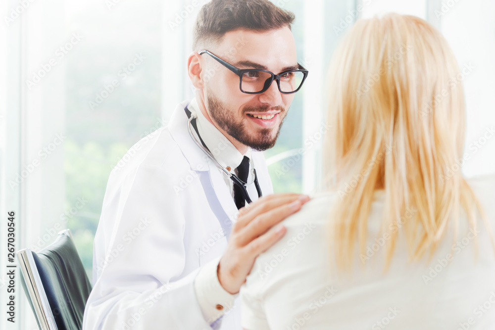 Male doctor is talking with female patient in hospital office. Healthcare and medical service.