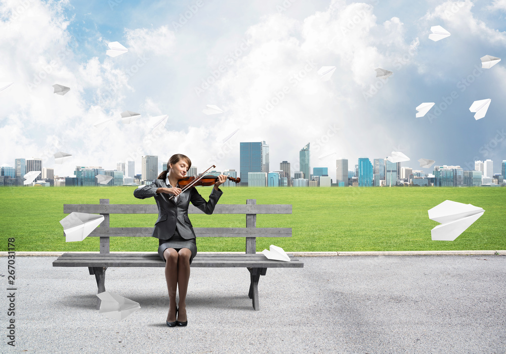 Young woman with violin sitting on wooden bench