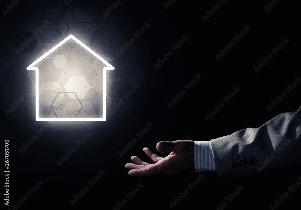 Conceptual image with hand pointing at house or main page icon on dark background