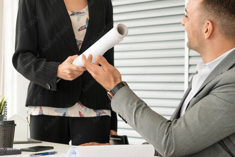 Businessman executive receive finished project from businesswoman worker in modern workplace office.