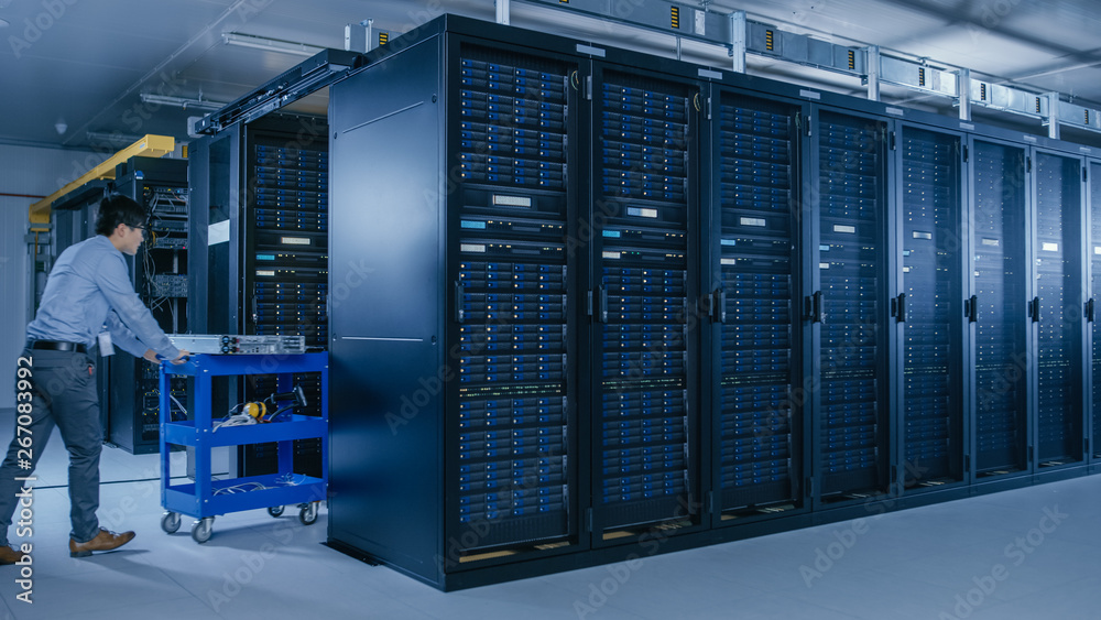 In the Modern Data Center: Team of IT Technicians Working with Server Racks, Running Maintenance and