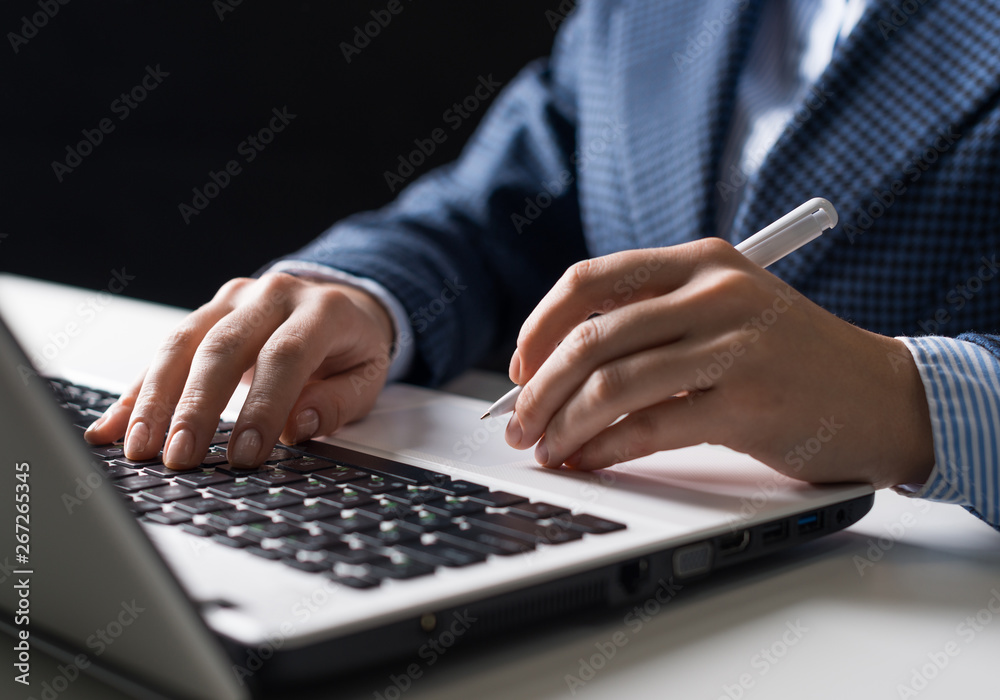 Man in business suit sitting at desk with laptop