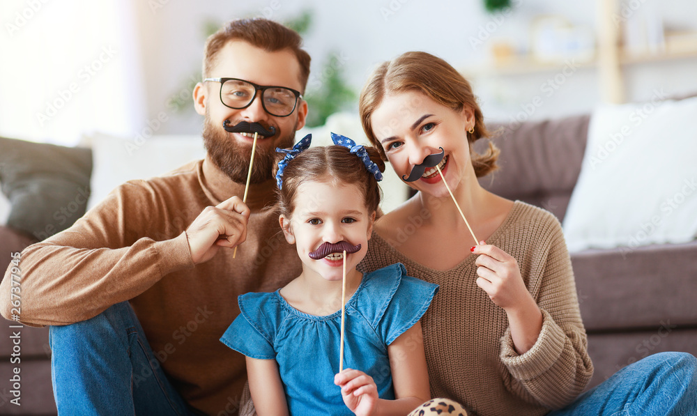 happy funny family mother father and child daughter with mustache on stick      .