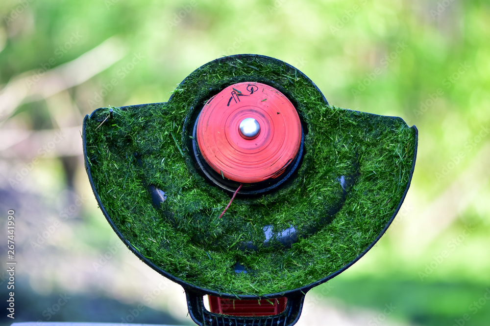 The simple mThoments of life, ordinary work in the garden -  man trimming grass with heavy-duty trim