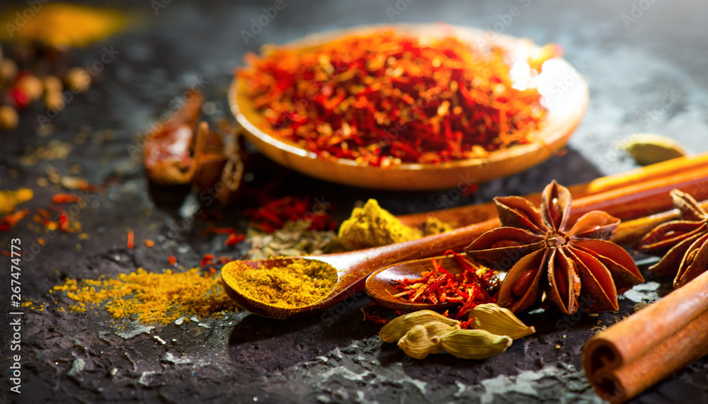 Spices. Various Indian spices on black stone table. Spice and herbs on slate background. Cooking ing