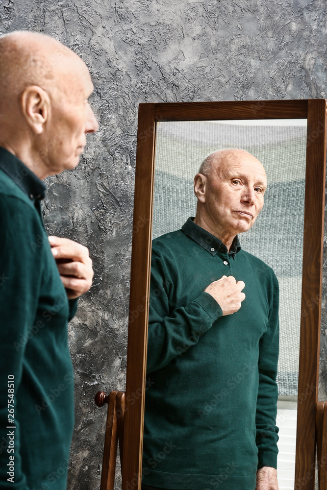 Senior man near mirror