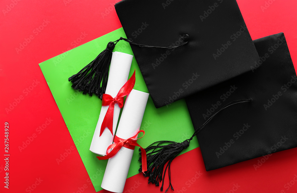 Mortar boards with diplomas on color background. Concept of high school graduation