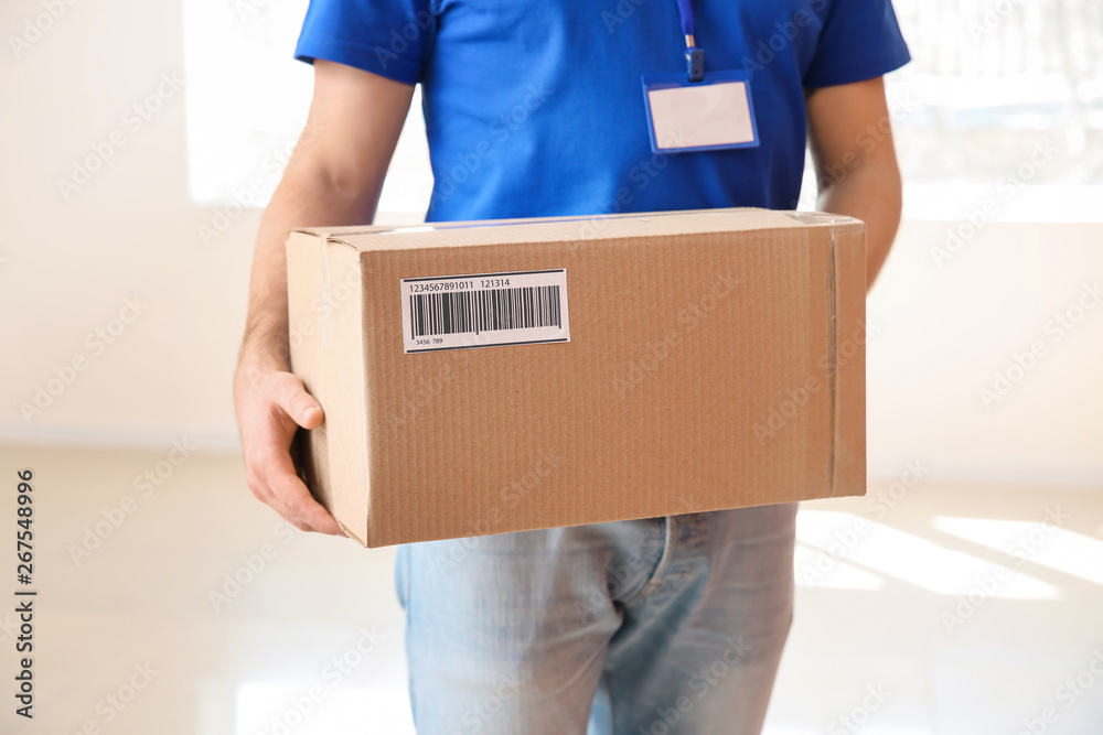 Delivery man with parcel indoors