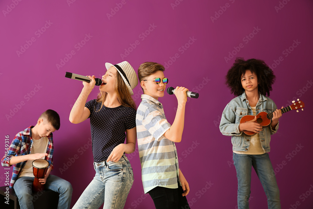 Teenage musicians playing against color background