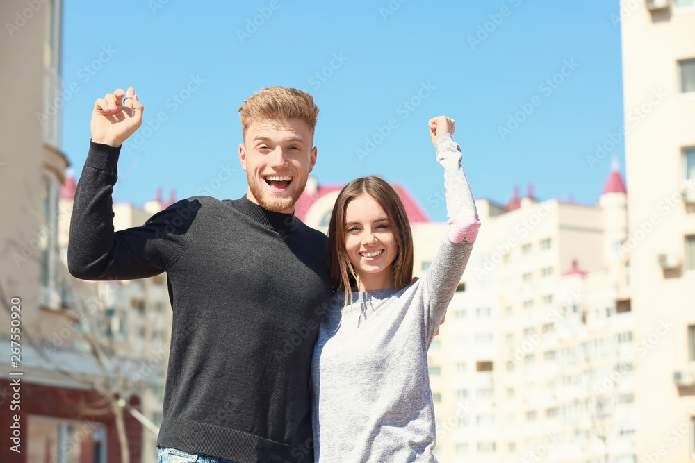 Young couple near their new house outdoors