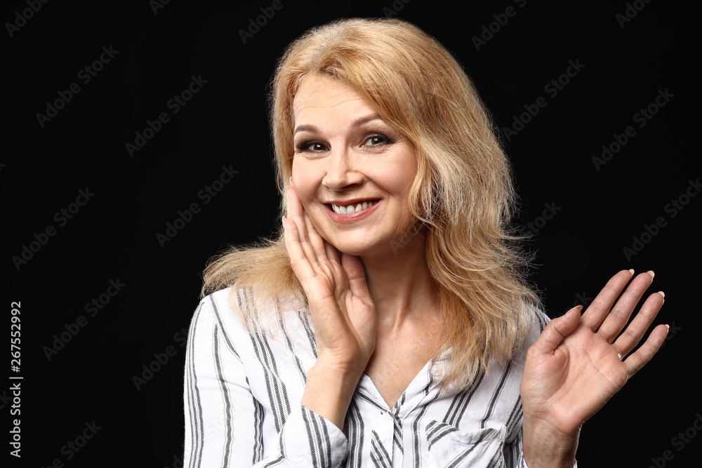 Portrait of beautiful mature woman on dark background