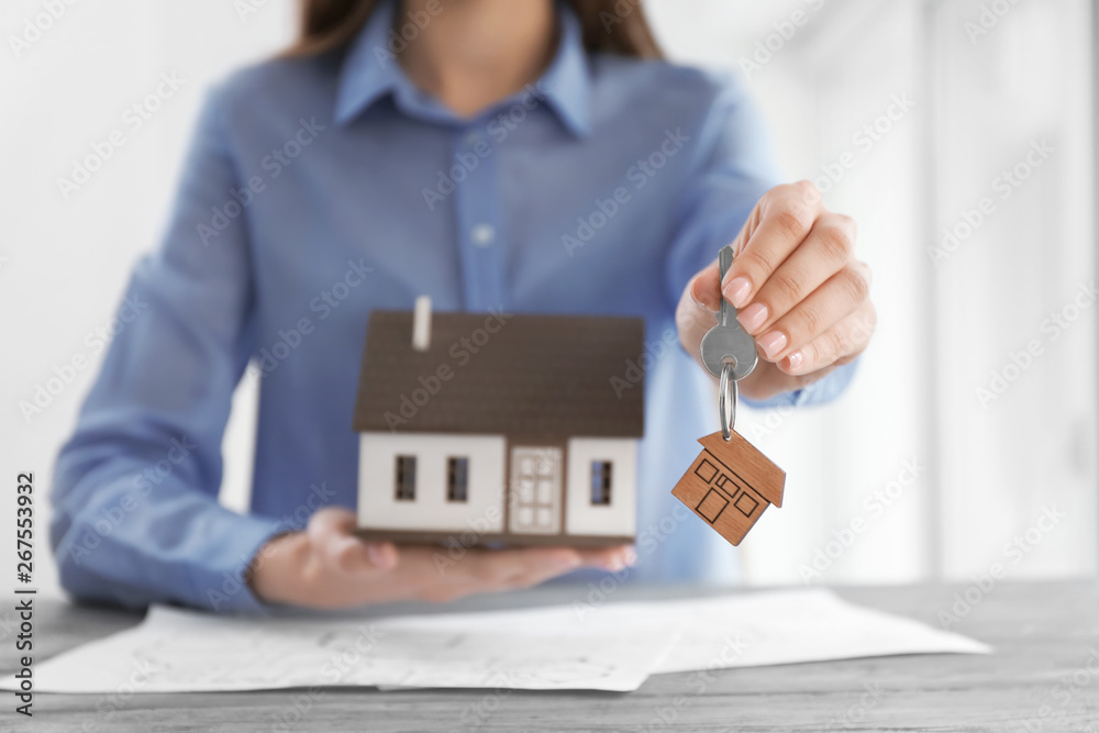 Real estate agent with key at table