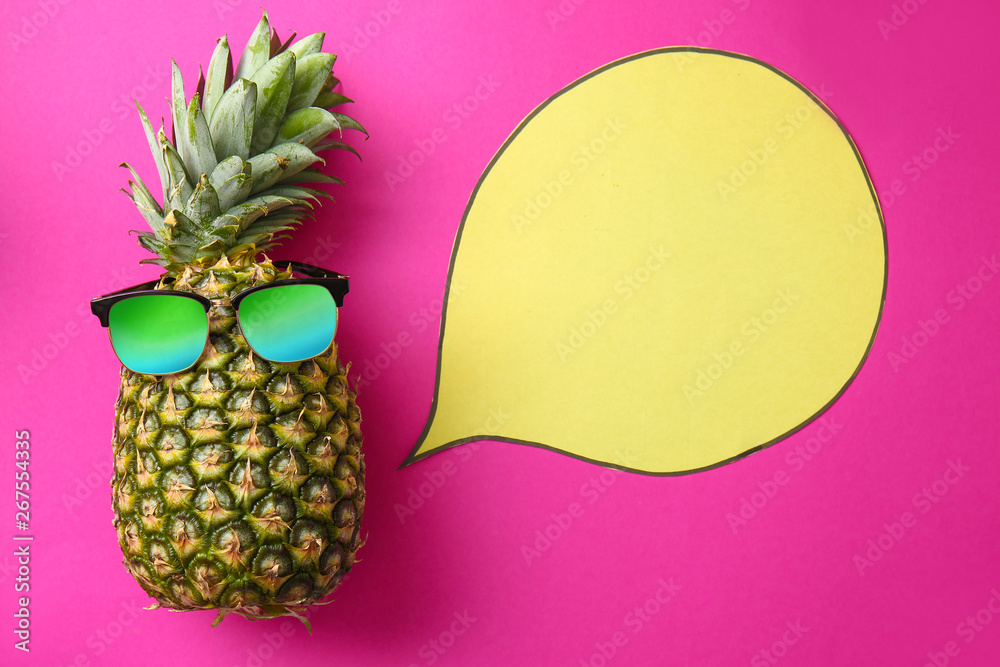 Ripe pineapple with sunglasses and blank speech bubble on color background