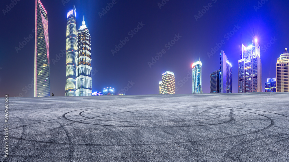 Asphalt race track and modern skyline and buildings in Shanghai at night,panoramic view