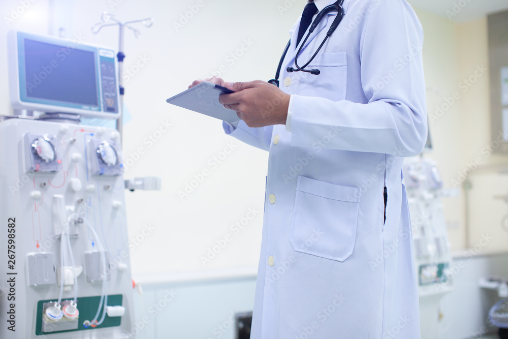 Side view of confident doctor in white medical uniform touching tablet with him finger at hospital,M