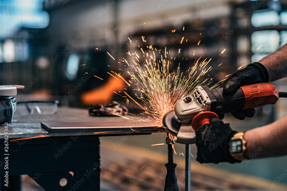 Grinding metal with small grinder, close-up.