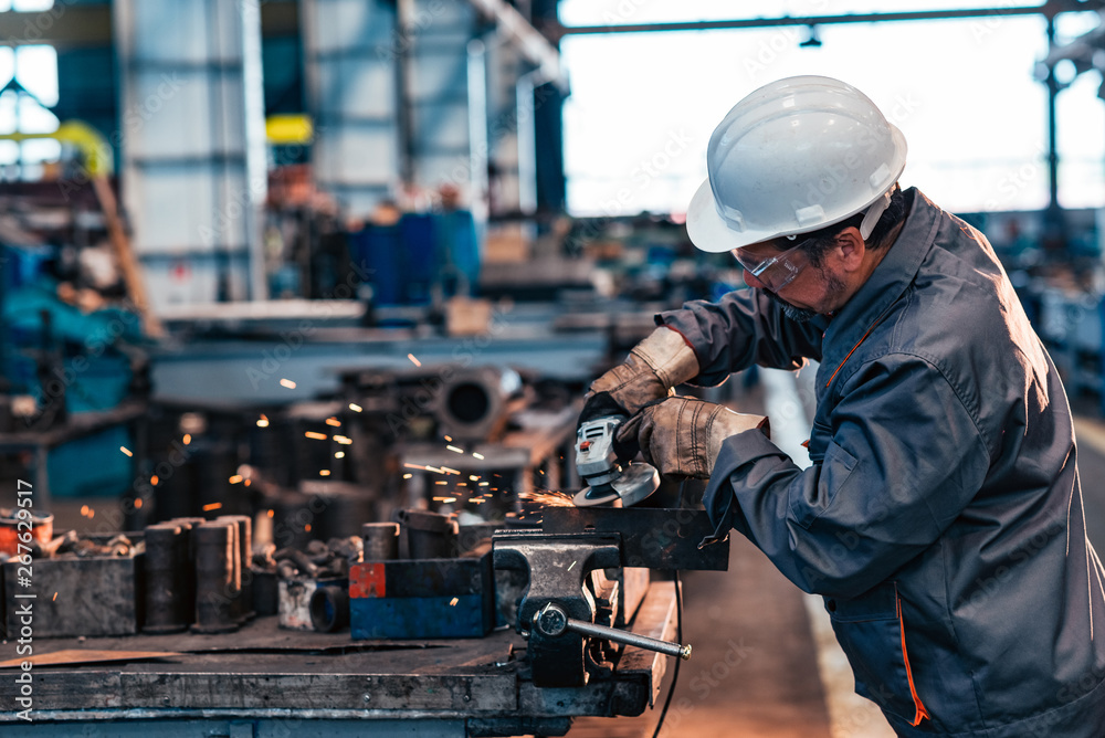 Man working with grinder at the factory.